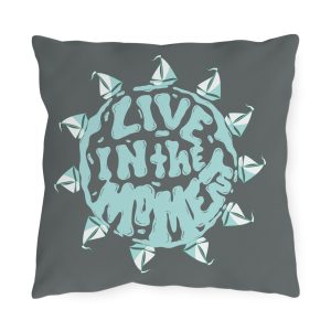 Sailing outdoor pillow with seafoam “Live in the Moment” text and paper boat sun design